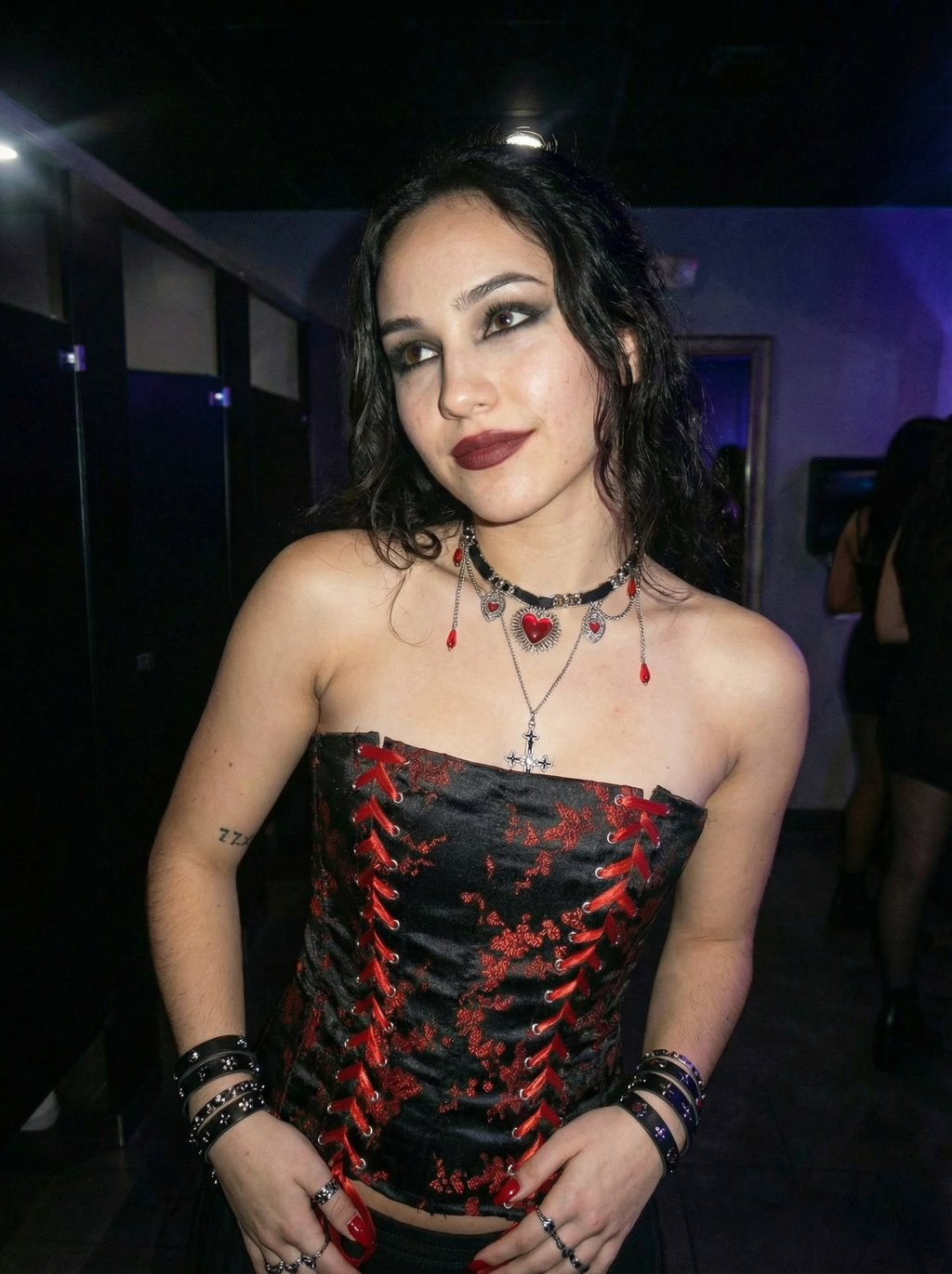 Model wearing the Blood Oath gothic red heart and cross necklace in a dimly lit indoor setting