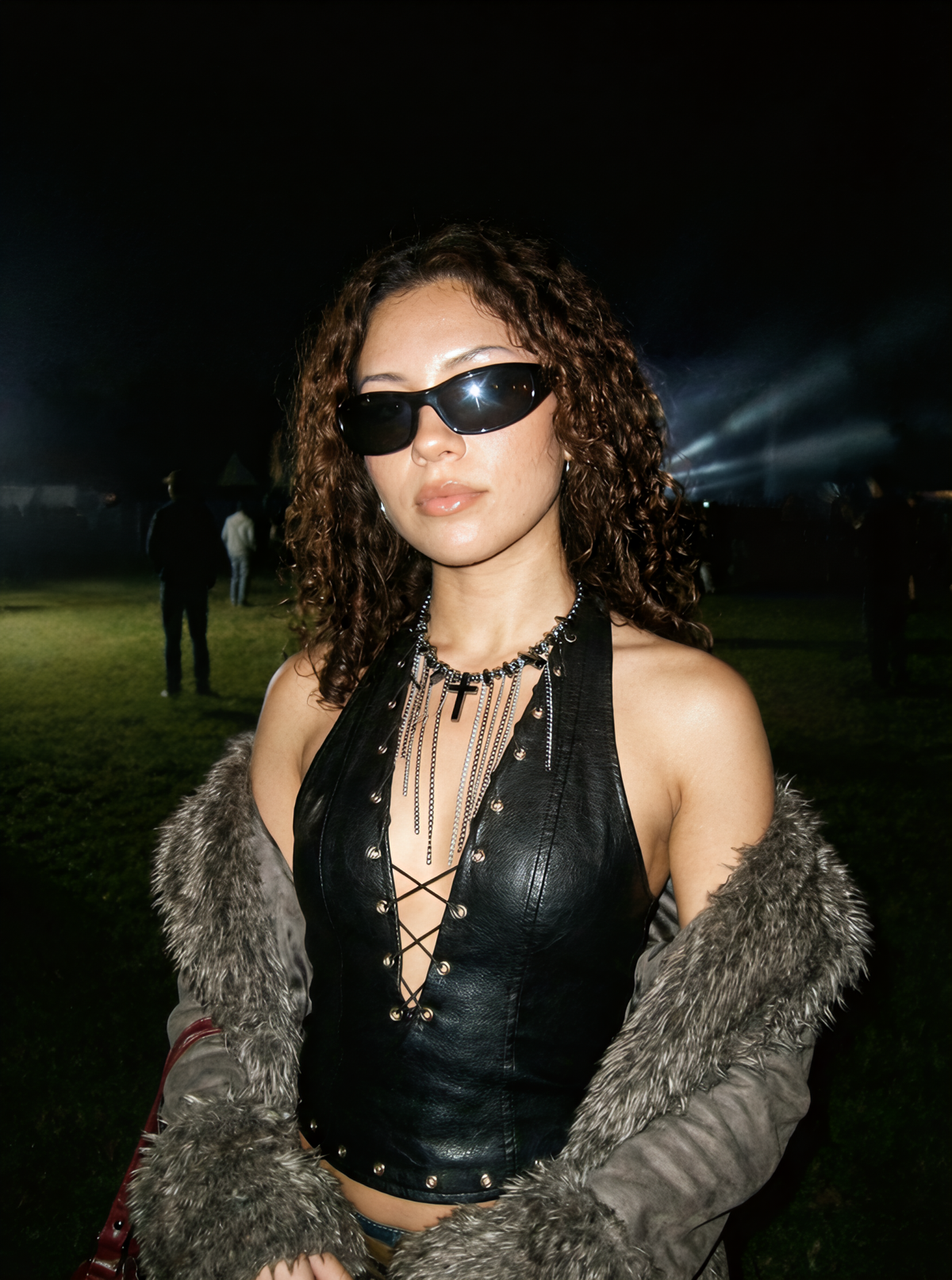 Model wearing the Chainfall Veil gothic cross fringe necklace at an outdoor nighttime event