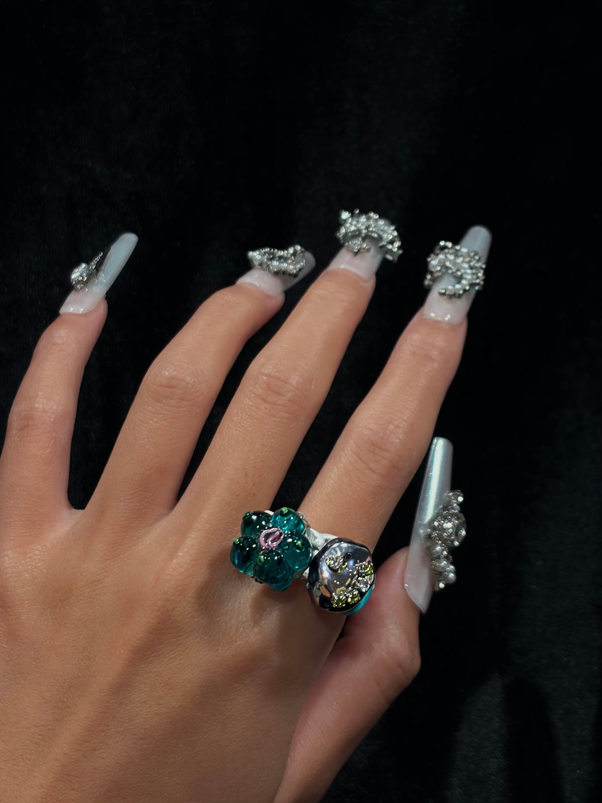 Hand wearing the handcrafted teal flower Y2K ring with translucent floral bead, pink detail and colorful beaded accents
