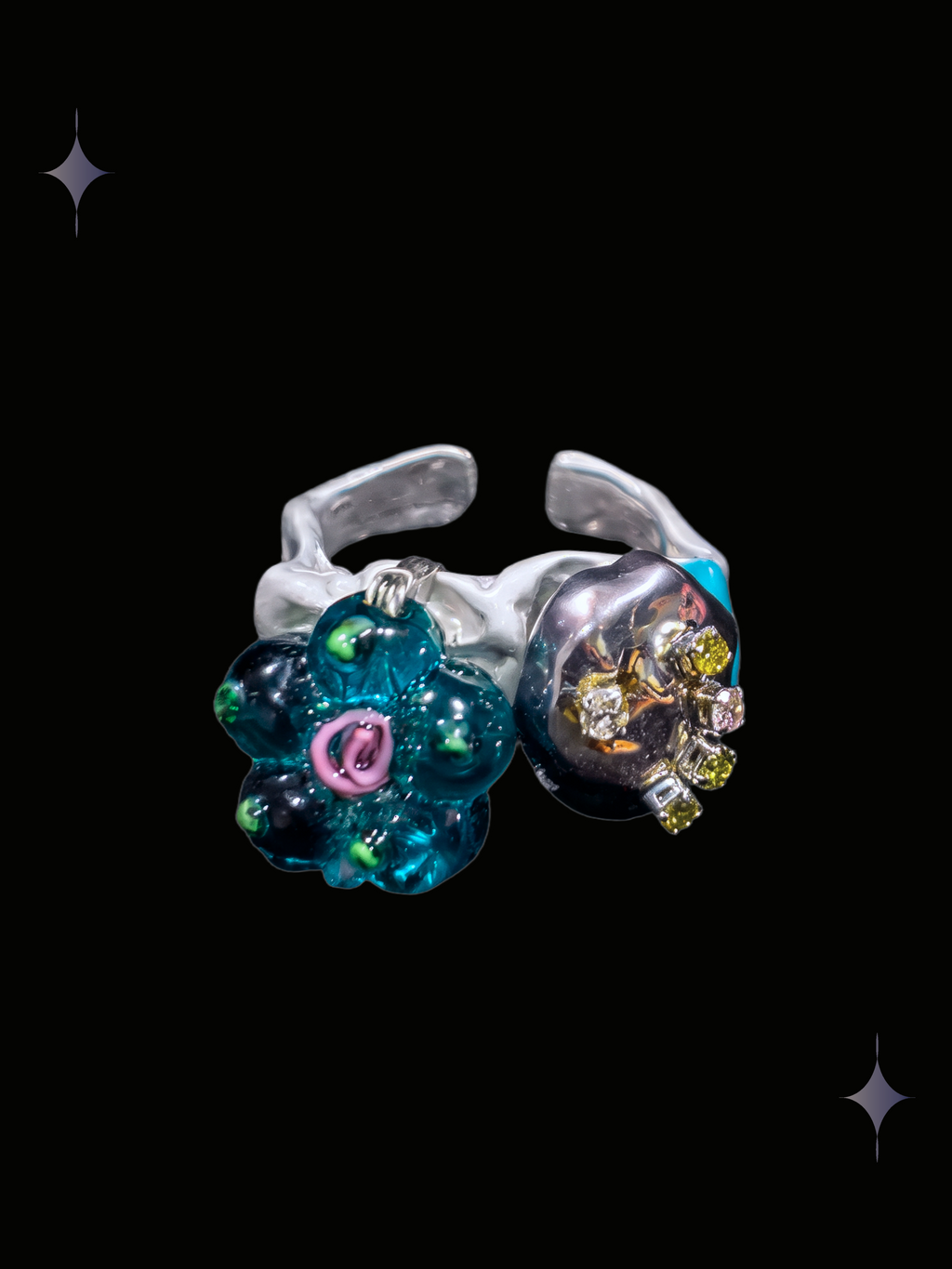 Handcrafted teal flower Y2K ring with translucent green floral bead, pink center, colorful accents and silver-tone details on a black background