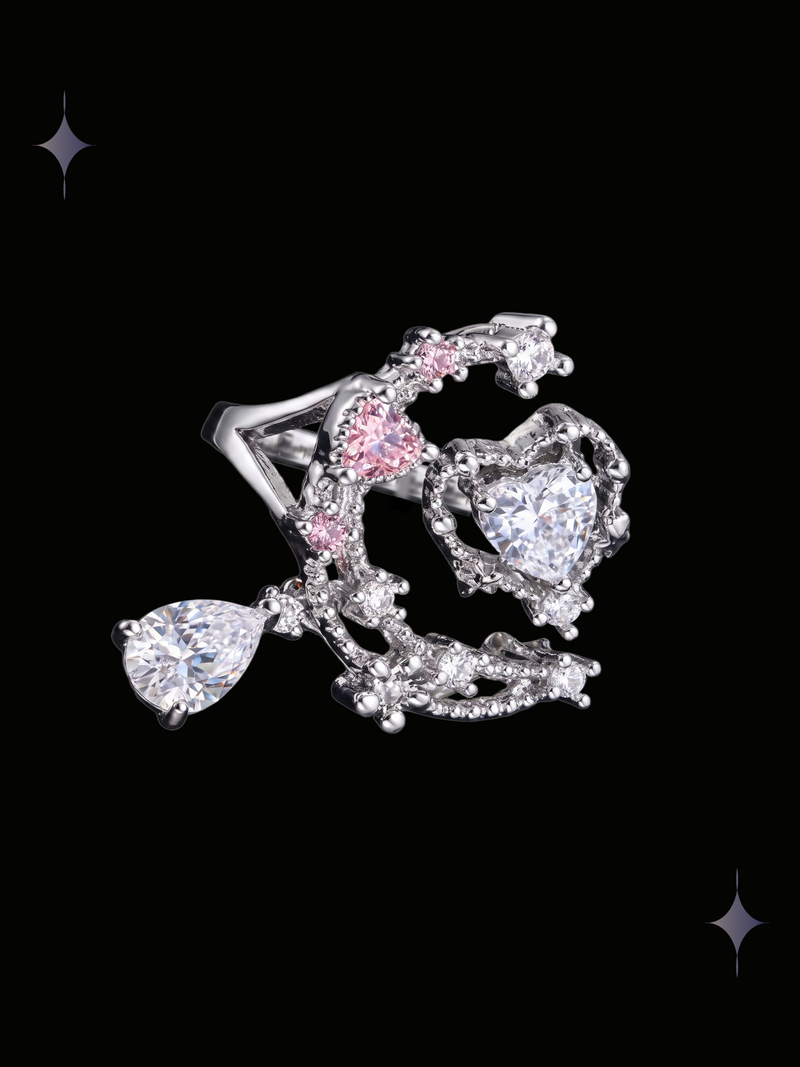 Moonlit Heart Y2K sparkling crescent moon ring with heart-shaped cubic zirconia, pink accents, and a dangling teardrop crystal on a black background