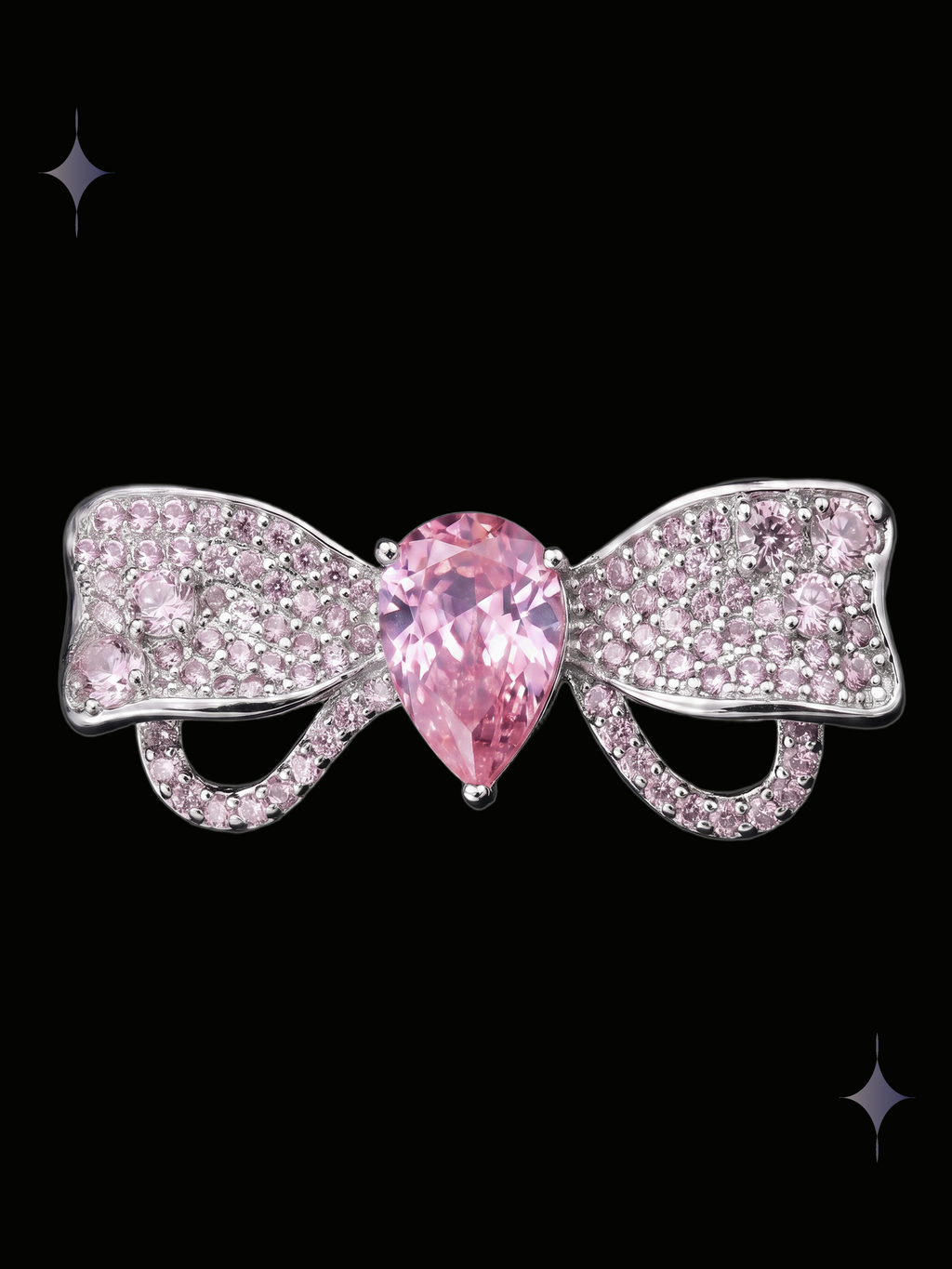Radiant Bow Y2K sparkling pink crystal statement ring with a large pear-shaped cubic zirconia and crystal-covered bow on a black background