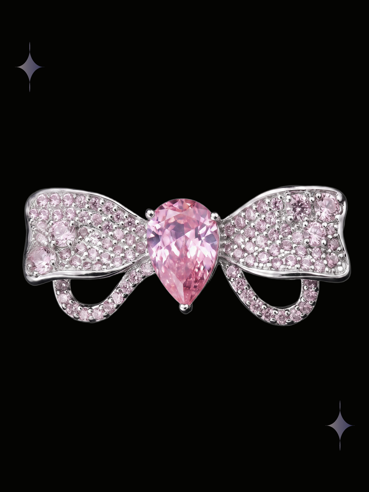 Radiant Bow Y2K sparkling pink crystal statement ring with a large pear-shaped cubic zirconia and crystal-covered bow on a black background