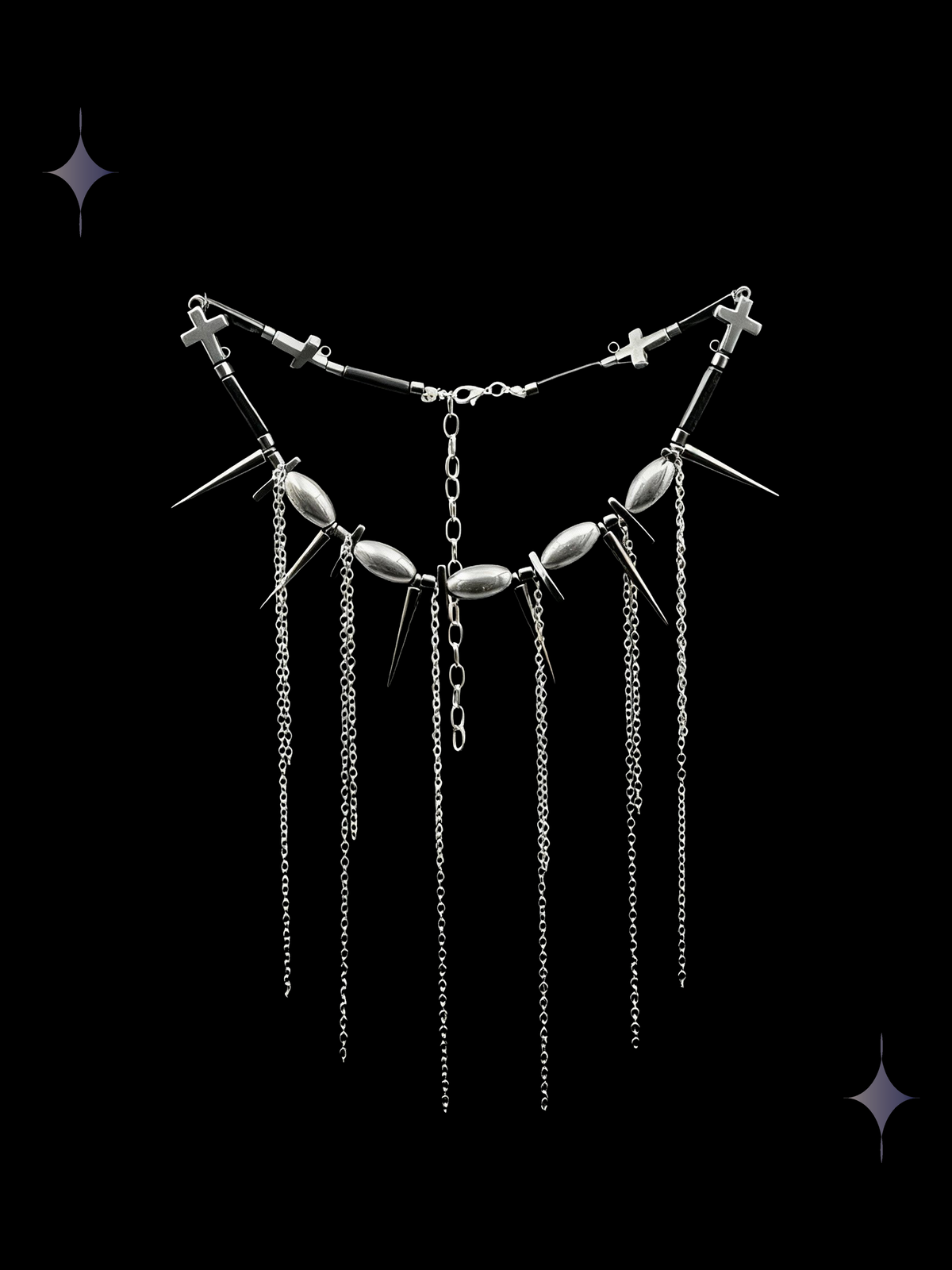 Spine Drip gothic spiked chain fringe necklace with gunmetal beads, pointed charms, cross details, and long silver-tone chain drops on a black background