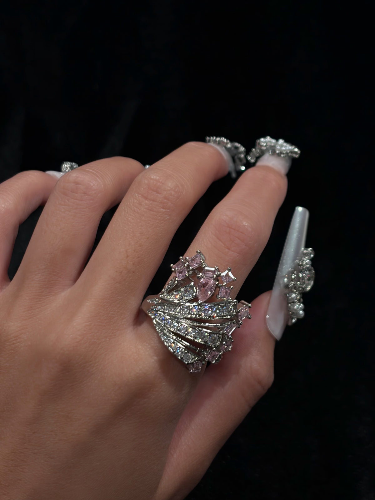 Hand wearing the Starlight Crown Y2K sparkling adjustable ring with pink cubic zirconia and a dramatic crown-inspired design